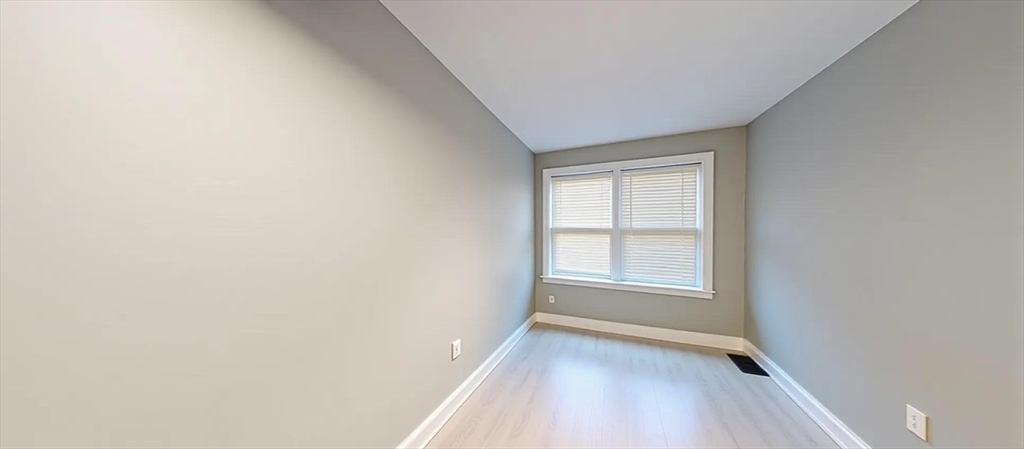 9 Anderson Street, Unit 1R Boston, MA 02114 - Photo 8 of 13 a view of an empty room with a window and wooden floor