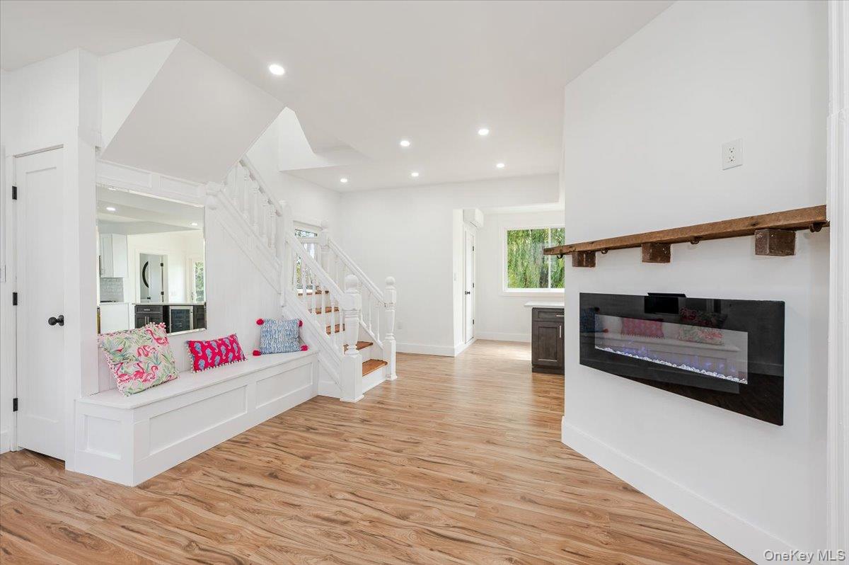 56 Oak Beach Road Babylon, NY 11702 - Photo 17 of 30 Entrance foyer with a modern wall - mounted fireplace providing a cozy focal point, luxury vinyl flooring and views towards the kitchen.