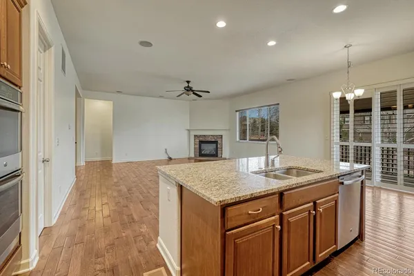 a kitchen with a granite countertop sink and refrigerator
