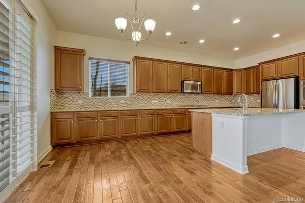 a kitchen with granite countertop a stove a sink and wooden floor
