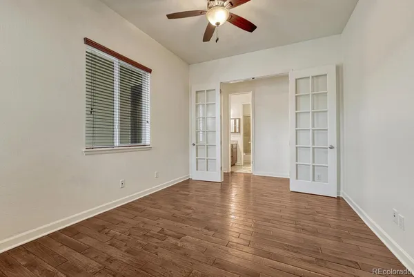 a view of an empty room with a window and wooden floor