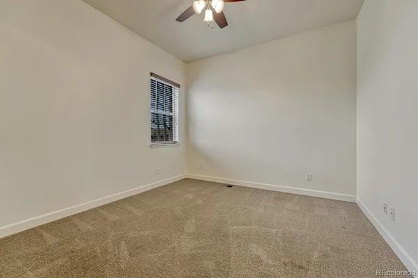 an empty room with a chandelier fan