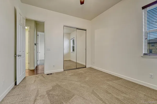 a view of an empty room with closet and a window