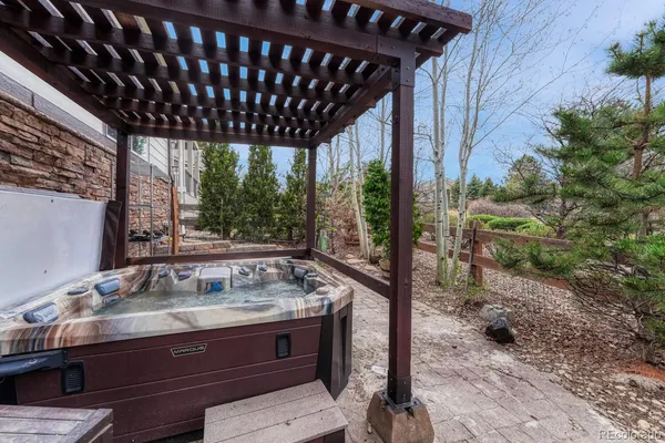 a patio with table and chairs and potted plants