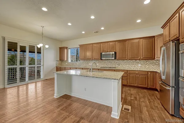 a kitchen with granite countertop wooden floors and wide window