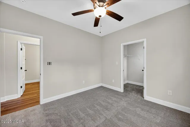 a bathroom with a granite countertop sink mirror vanity and toilet