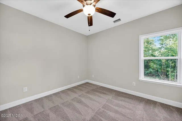 an empty room with closet and fan