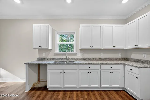 an empty room with wooden floor chandelier and windows