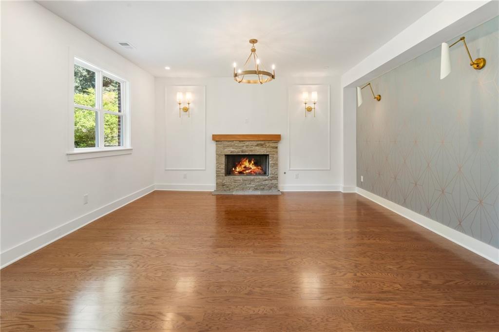 3711 Mountain Cove Road Snellville, GA 30039 - Photo 30 of 78 an empty room with windows fireplace and wooden floor