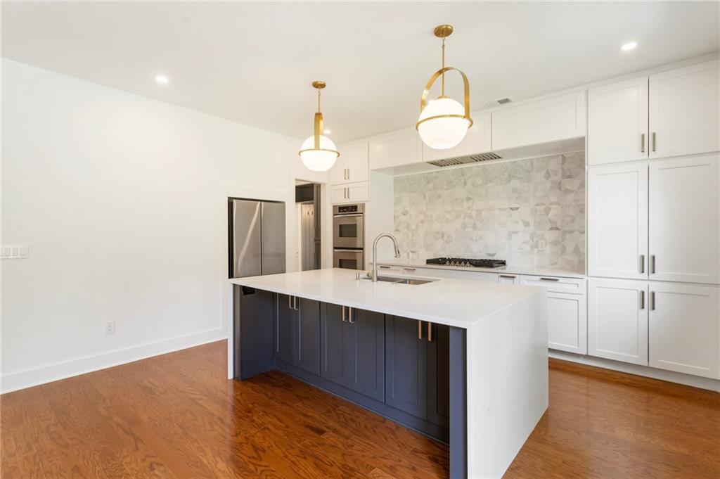 3711 Mountain Cove Road Snellville, GA 30039 - Photo 33 of 78 a kitchen with kitchen island a sink stainless steel appliances and cabinets