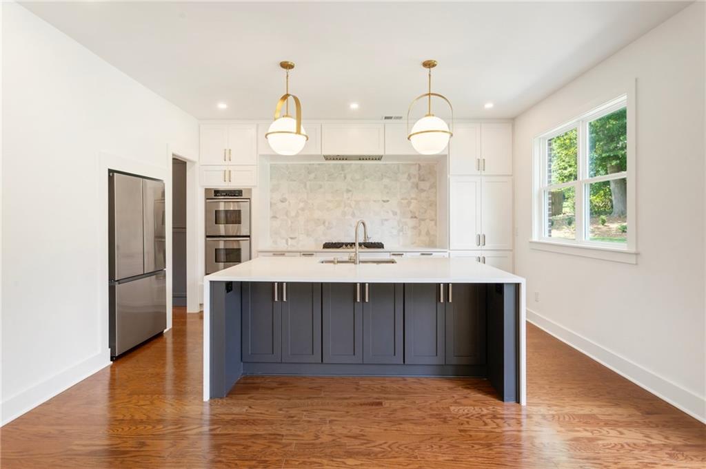 3711 Mountain Cove Road Snellville, GA 30039 - Photo 35 of 78 a kitchen with a sink a refrigerator and wooden floor