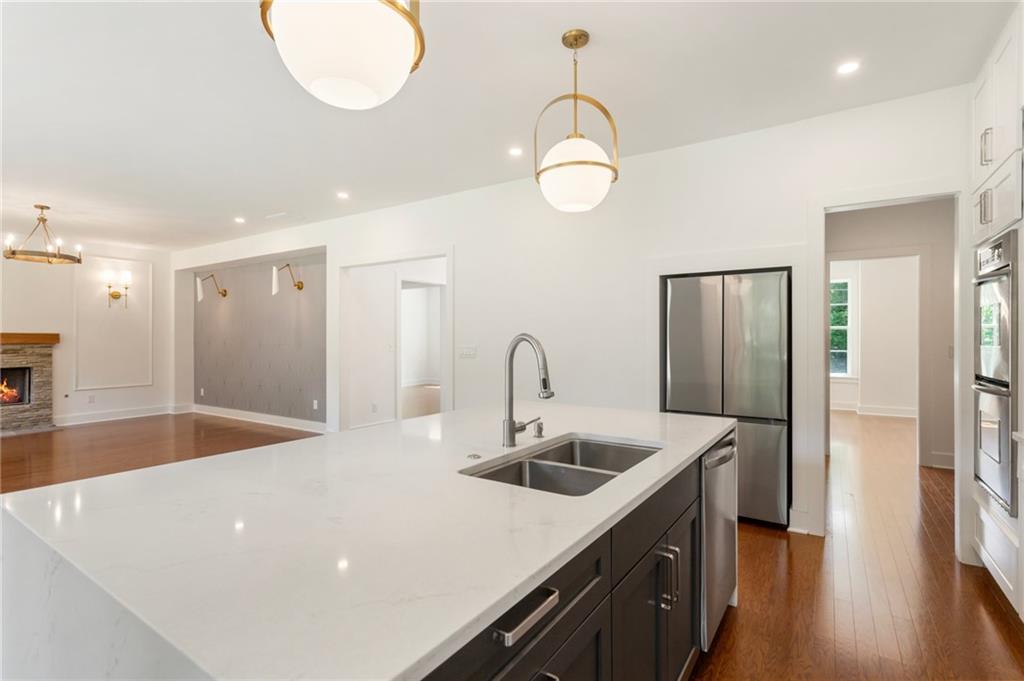 3711 Mountain Cove Road Snellville, GA 30039 - Photo 37 of 78 a kitchen with stainless steel appliances a sink dishwasher a refrigerator and a stove with wooden floor