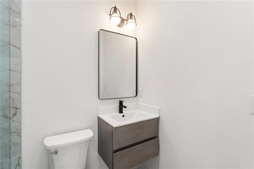 3711 Mountain Cove Road Snellville, GA 30039 - Photo 63 of 78 a bathroom with a sink a toilet and mirror