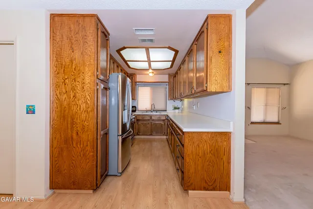 a kitchen with stainless steel appliances granite countertop a sink dishwasher stove and microwave with wooden cabinets