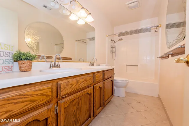 a bathroom with a sink a toilet a mirror and shower