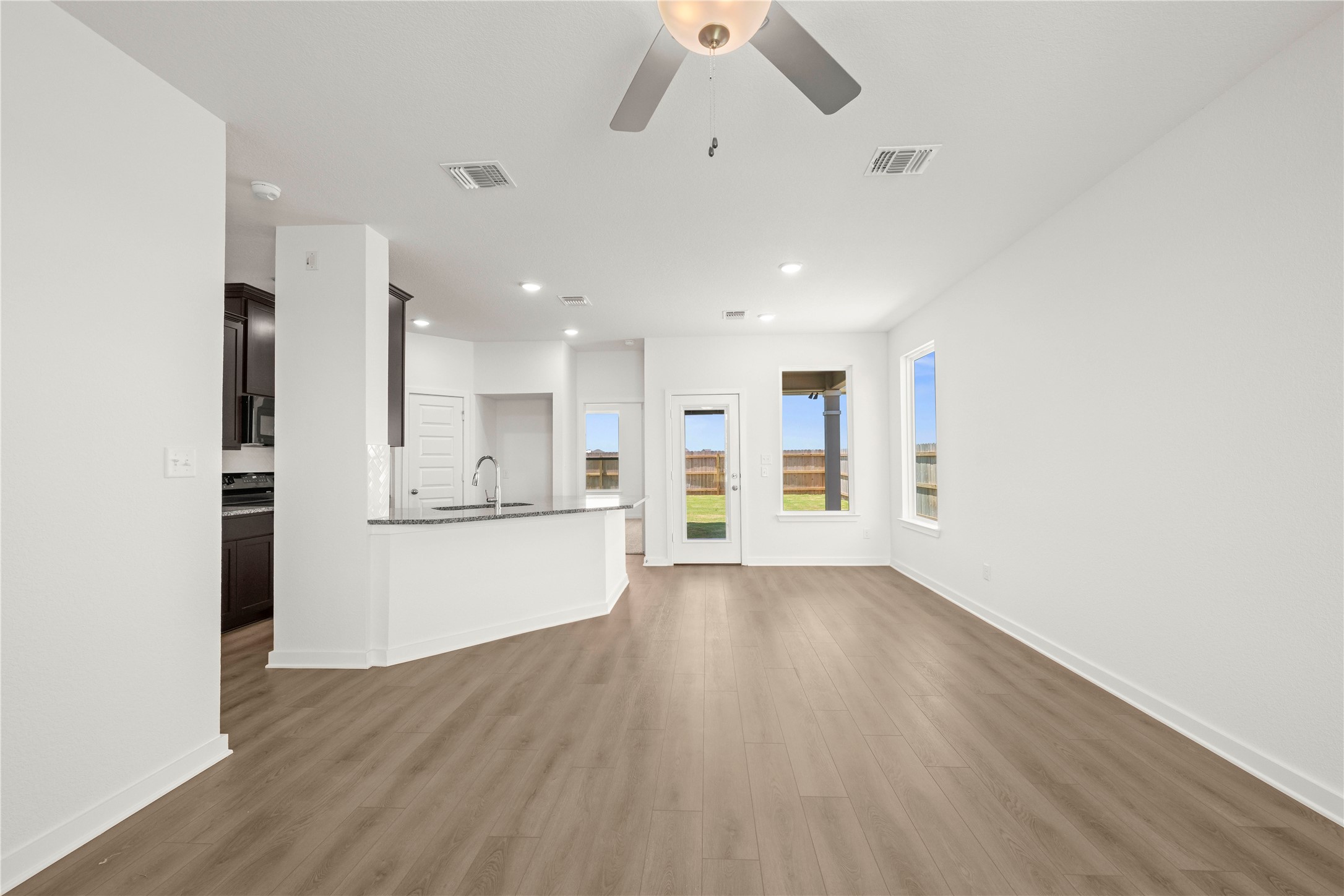 228 Gus Loop Georgetown, TX 78626 - Photo 14 of 19 Natural light floods this inviting living area, showcasing sleek flooring and a contemporary open-concept layout.