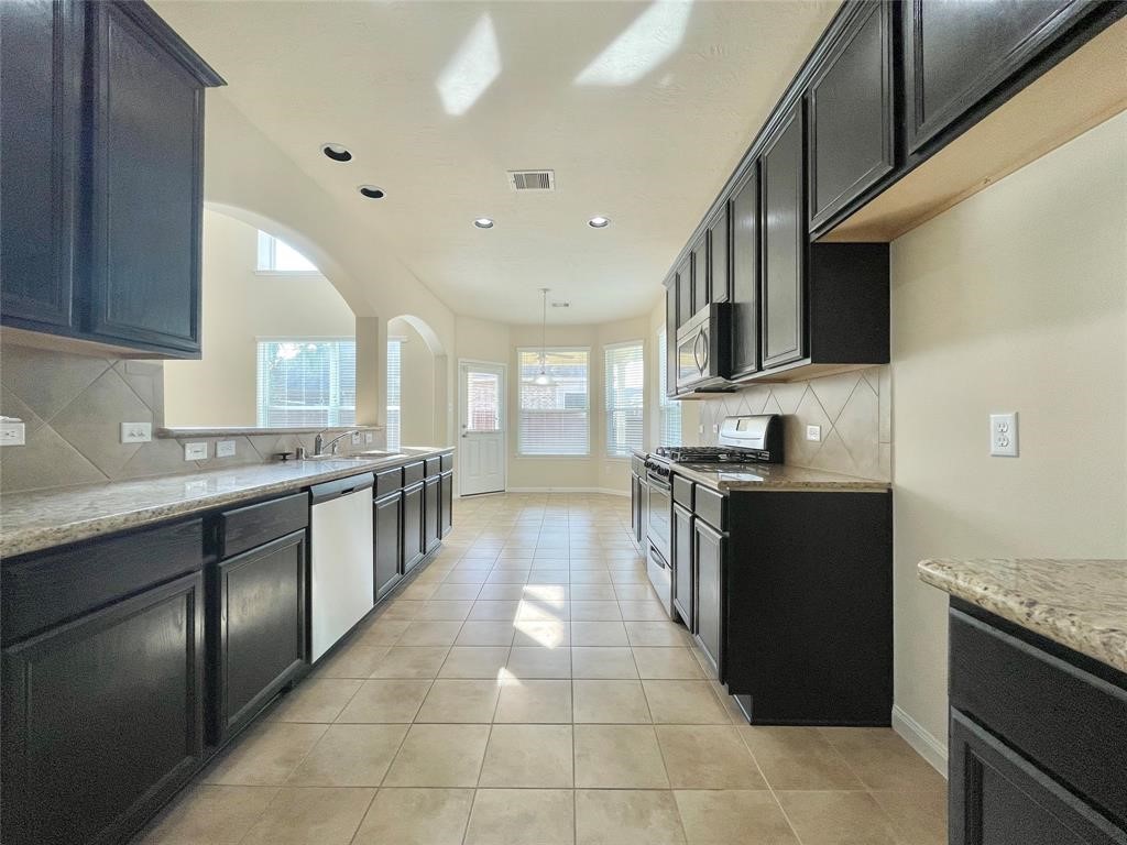 25015 Diamond Ranch Drive Katy, TX 77494 - Photo 9 of 27 a large kitchen with stainless steel appliances granite countertop a stove and a sink