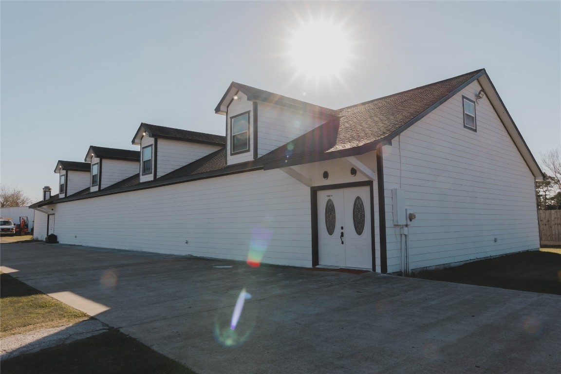 918 Fresa Road Pasadena, TX 77502 - Photo 27 of 47 This Modern, multi-level VENUE/EVENT white building with dormer windows and a large driveway. The sun shines brightly, highlighting the clean lines and spacious exterior.