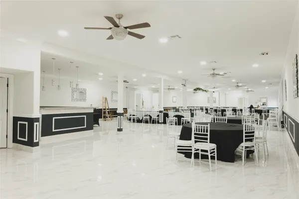 a large kitchen with a large counter top a sink stainless steel appliances and cabinets