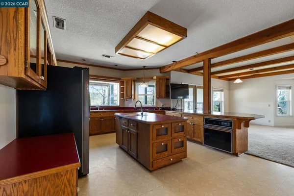 a large kitchen with stainless steel appliances granite countertop a stove a sink dishwasher and a refrigerator