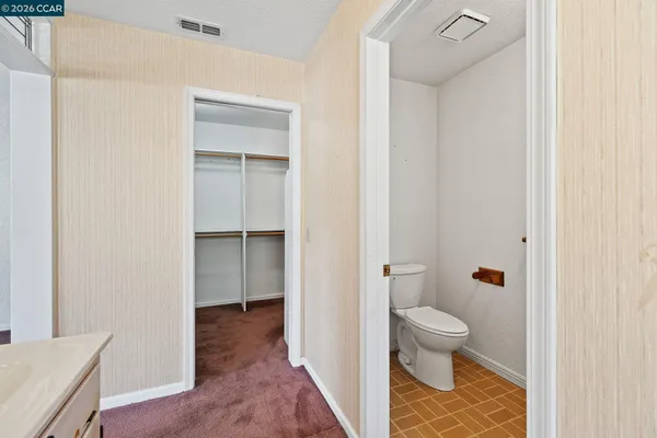 an empty room with windows and chandelier fan