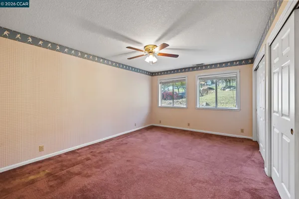 an empty room with chandelier fan