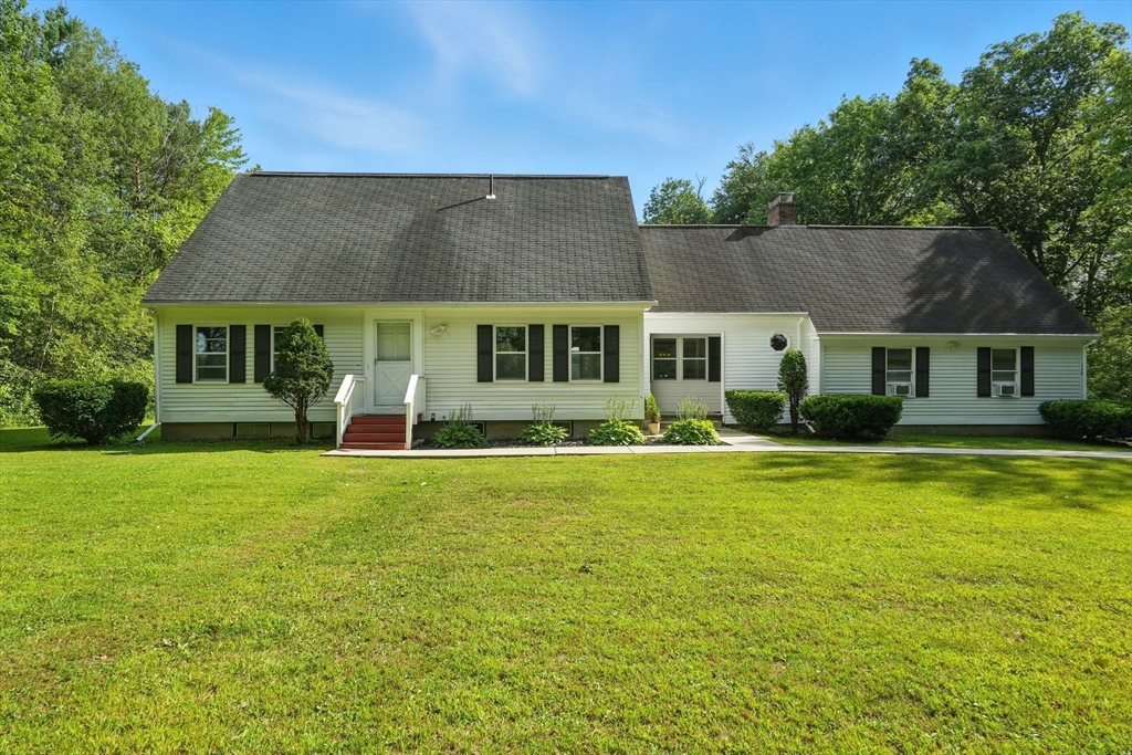 a front view of a house with swimming pool having outdoor seating
