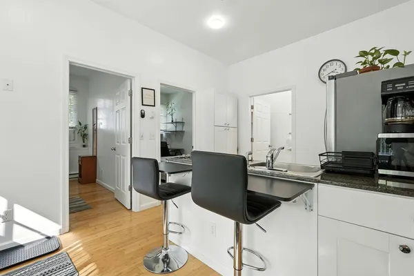 a kitchen with a sink and chairs