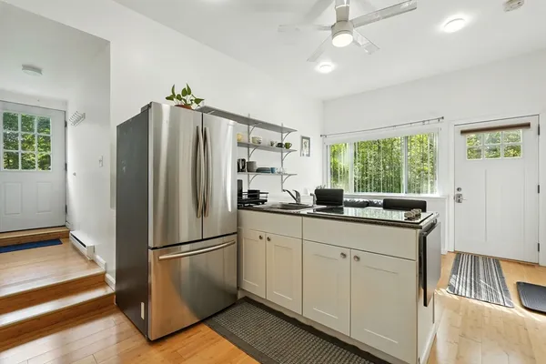 a kitchen with granite countertop a refrigerator and a sink