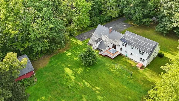an aerial view of residential house with outdoor space and trees all around
