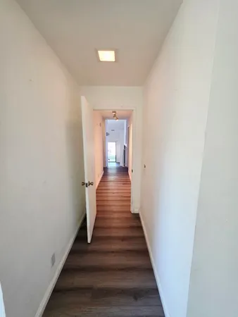 a view of a hallway with wooden floor