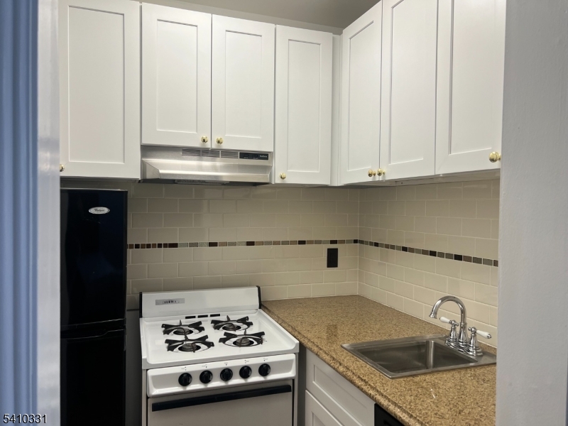 15 Montclair Avenue, Unit 2 Montclair, NJ 07042 - Photo 9 of 10 a kitchen with granite countertop a sink stove and cabinets