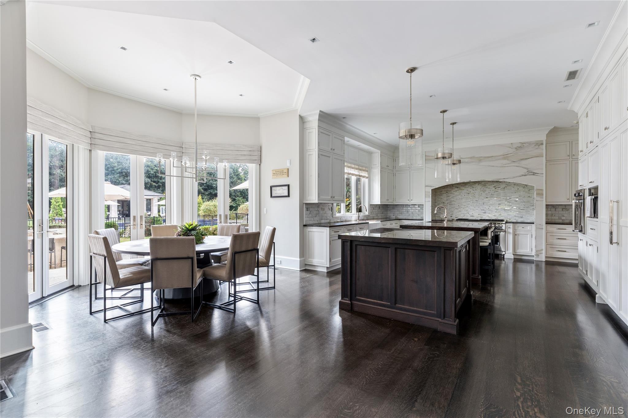 53 Simonson Road Glen Head, NY 11545 - Photo 17 of 43 a open kitchen with stainless steel appliances granite countertop a stove a refrigerator a kitchen island a dining table and chairs with wooden floor