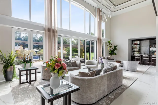 a living room with couches a coffee table and a large window with garden view