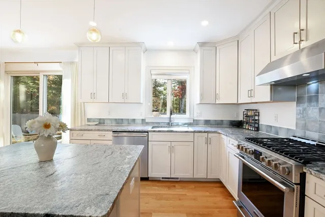 a kitchen with a stove a sink and a granite counter tops