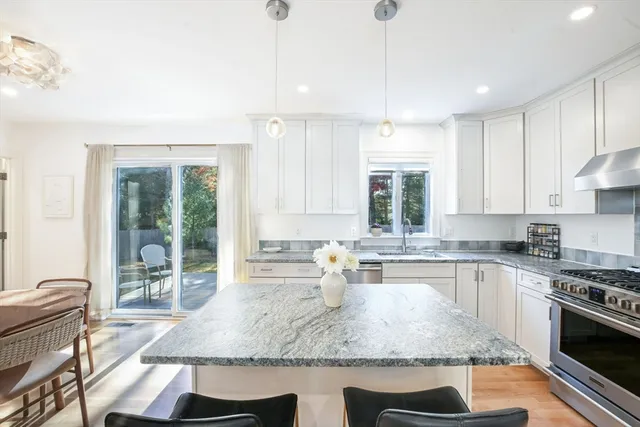 a kitchen with kitchen island granite countertop a stove a sink and a counter top space