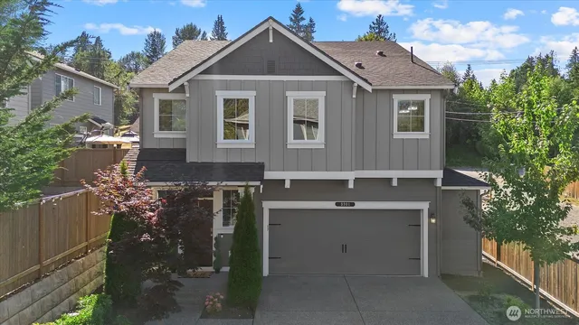 an aerial view of a house with a yard and large tree