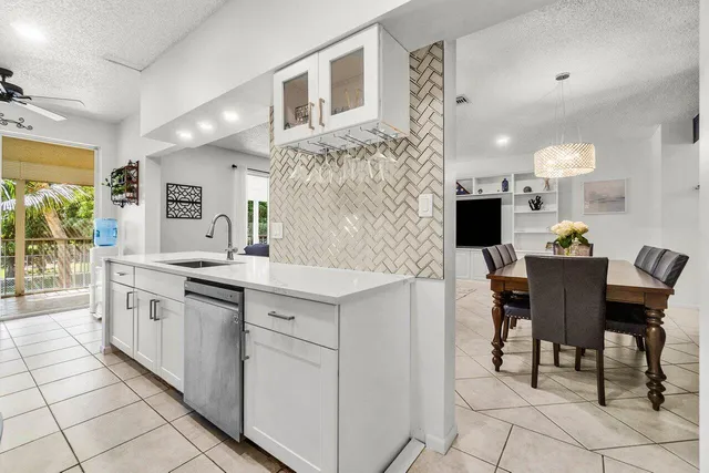 a large kitchen with cabinets chairs and entryway