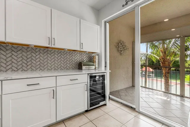 a kitchen with white cabinets and outdoor space