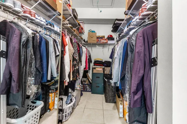 a view of walk in closet with clothes and shoes