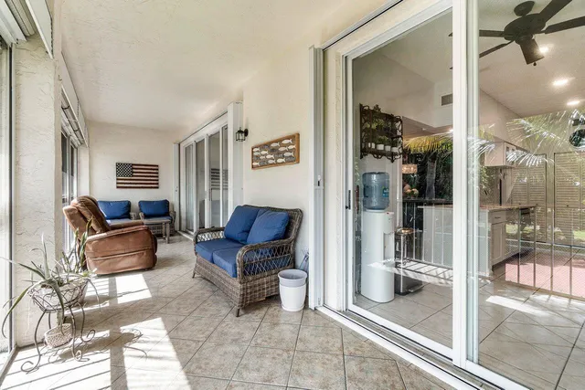a living room with furniture and a glass door shower