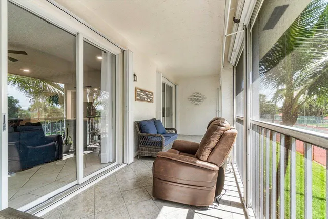 a living room with furniture a floor to ceiling window and walls