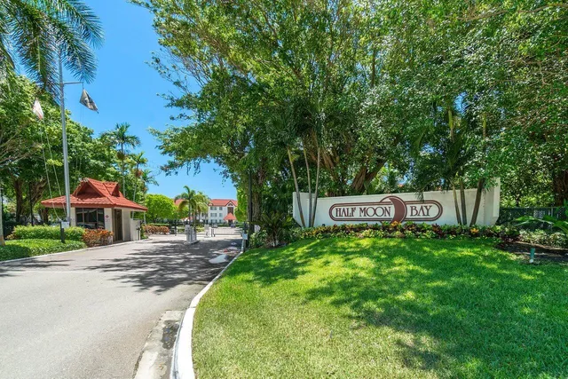 a backyard of a house with table and chairs a fire pit and a large tree