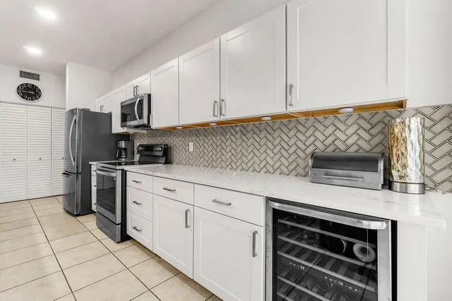 a kitchen with stainless steel appliances white cabinets and a stove top oven