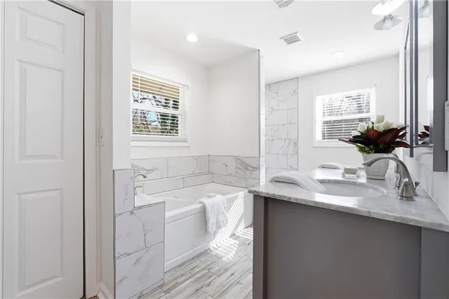 a bathroom with a sink a large mirror and a bathtub