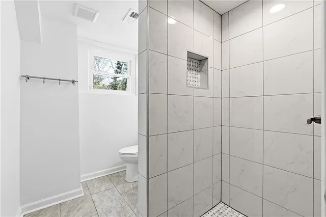 a bathroom with a toilet and a shower