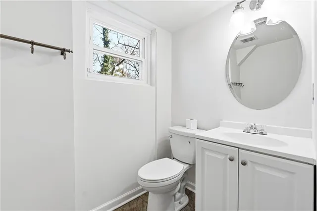 a bathroom with a toilet sink and mirror