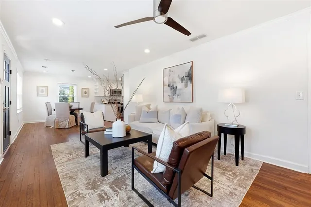 a living room with furniture and a wooden floor