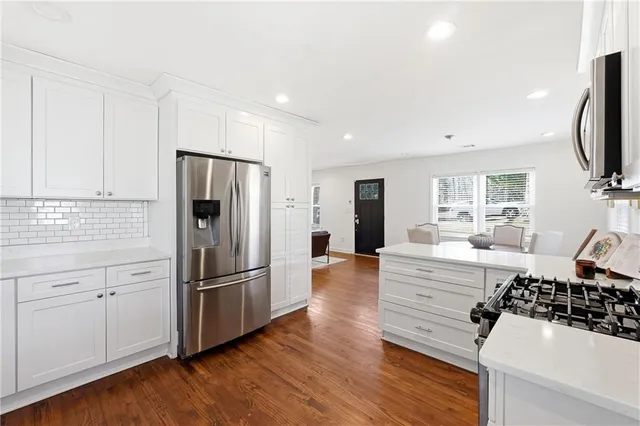 a kitchen with stainless steel appliances a refrigerator and a stove top oven