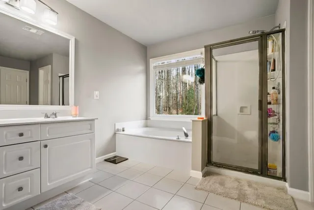 a bathroom with a shower sink vanity and mirror